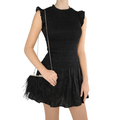 Woman in Black Dress Holding ESTELLE Feather Clutch Black Front View - Olga Berg